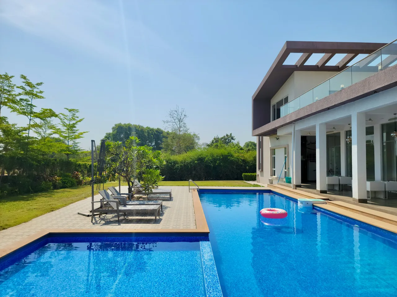 Piscina azul junto a una vivienda moderna